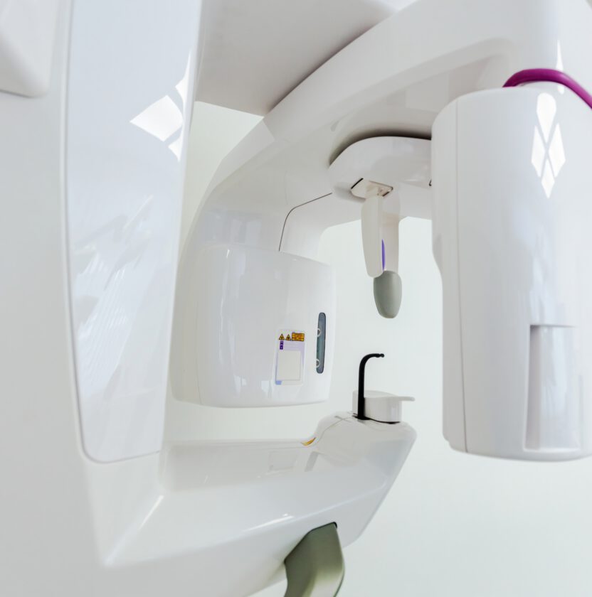 A dental cone-beam CT scanner in a bright clinic room (stock photograph, not the practice’s equipment)