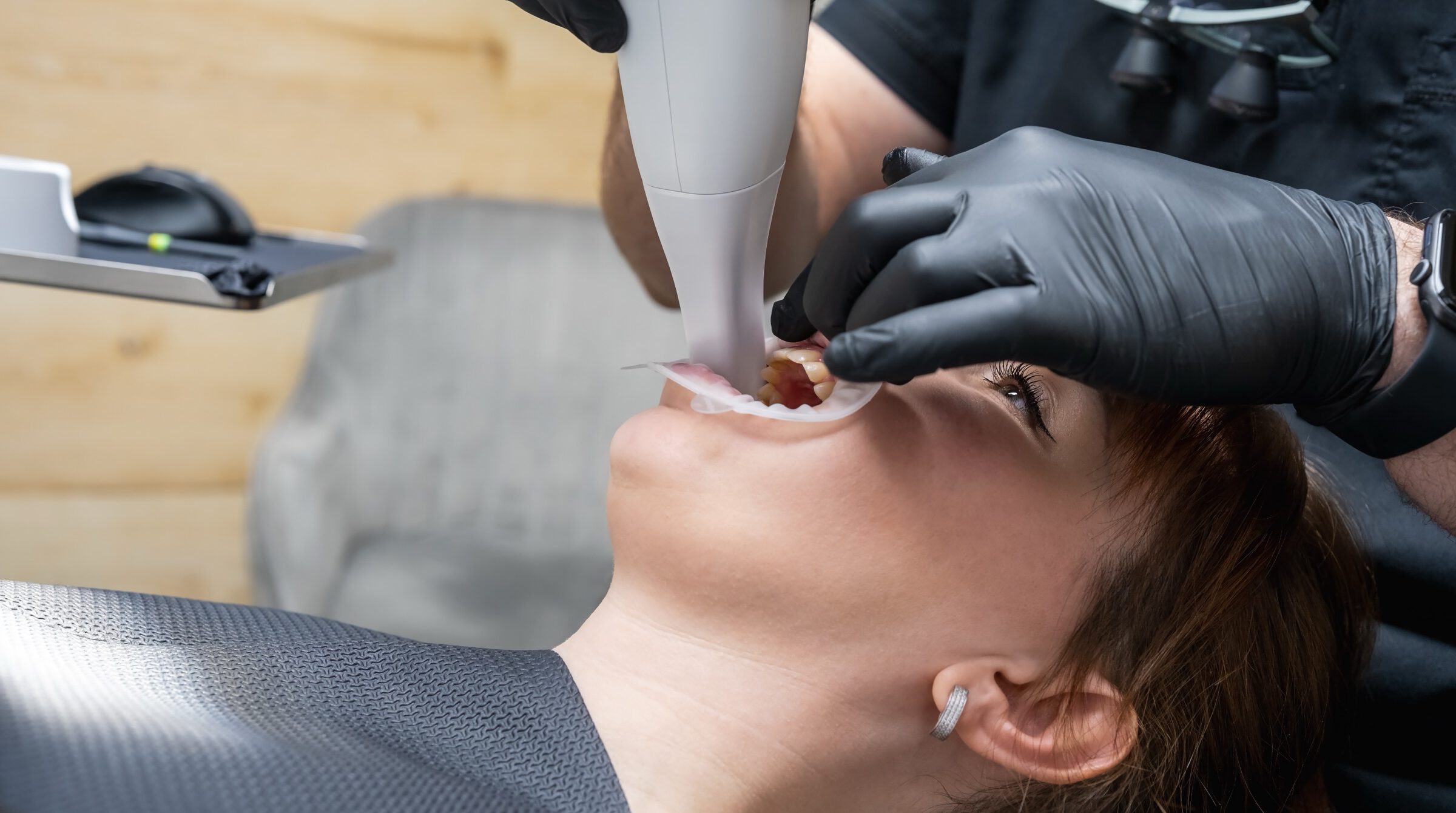 Close view of a handheld intraoral scanner being used in a patient's mouth